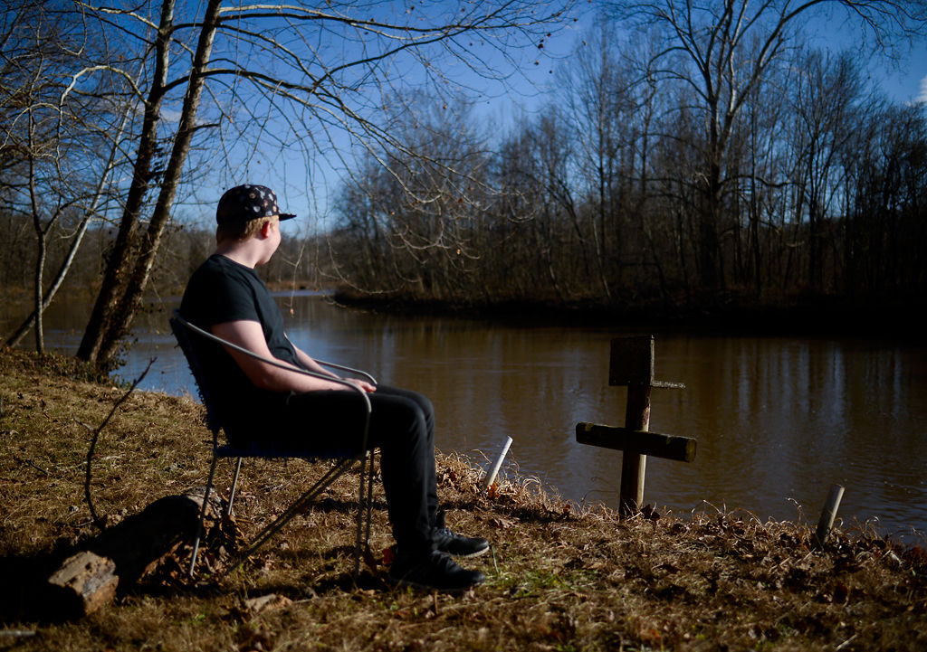 Gary Edge's son poses for a portrait next to a lake in Versailles, Missouri